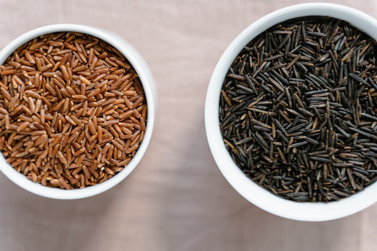 Bowls of brown and black rice showcasing different whole grain options.