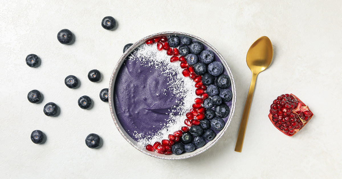 Bowl of açai smoothie with fresh berries and granola, a kidney-friendly breakfast choice rich in antioxidants.