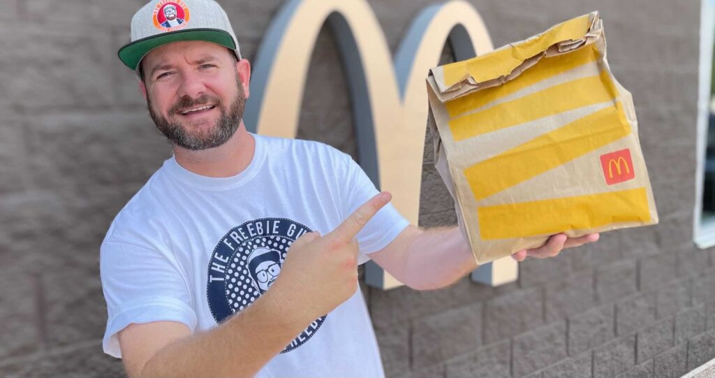 Man holding a McDonald's bag and drink.