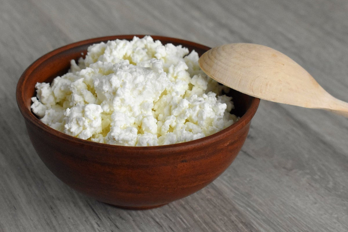 Bowl of fresh cottage cheese, a high-protein dairy food with debated health benefits due to sodium and fat content.