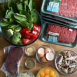 Ingredients for a balanced homemade dog food recipe laid out on a table.