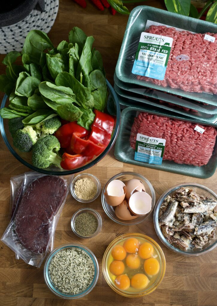 Ingredients for a balanced homemade dog food recipe laid out on a table.