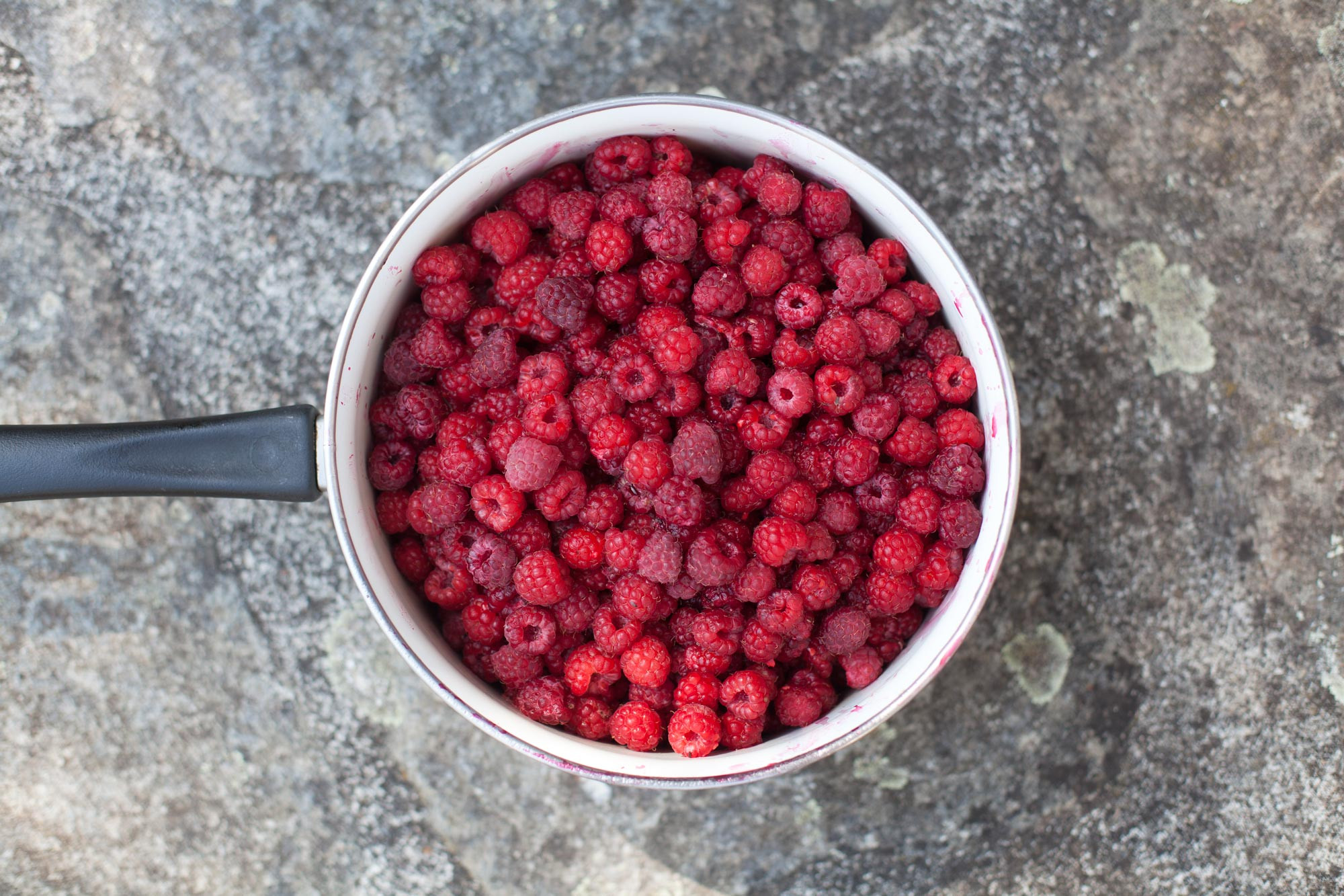 Raspberries simmering in a pan on the stovetop.