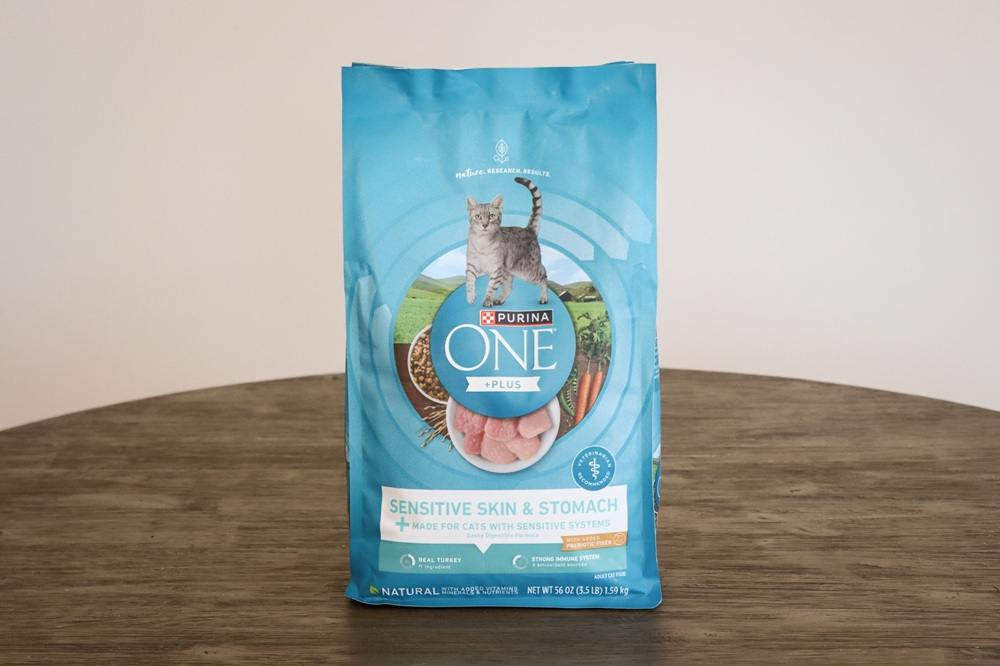 Close-up of Purina ONE +Plus Sensitive Skin &amp; Stomach kibble, showcasing its texture and ingredients