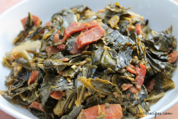 A plate of vibrant green collard greens seasoned with bacon and spices.