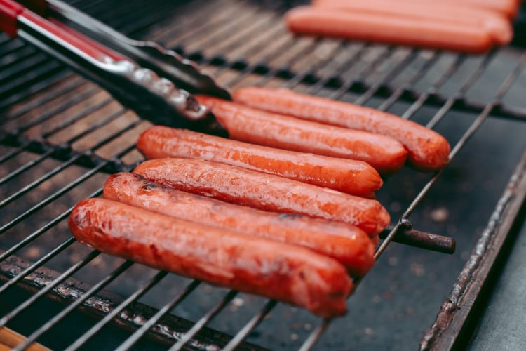 Sausages cooking on a grill.