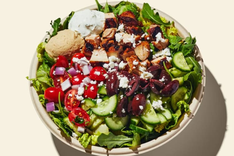 A colorful salad with grilled chicken, vegetables, and a light dressing.