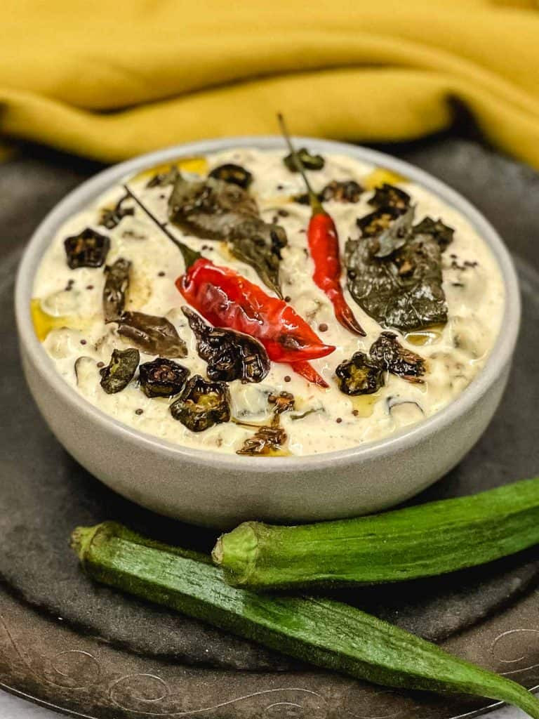 A refreshing bowl of Raita with cucumber and herbs, perfect as a side dish.