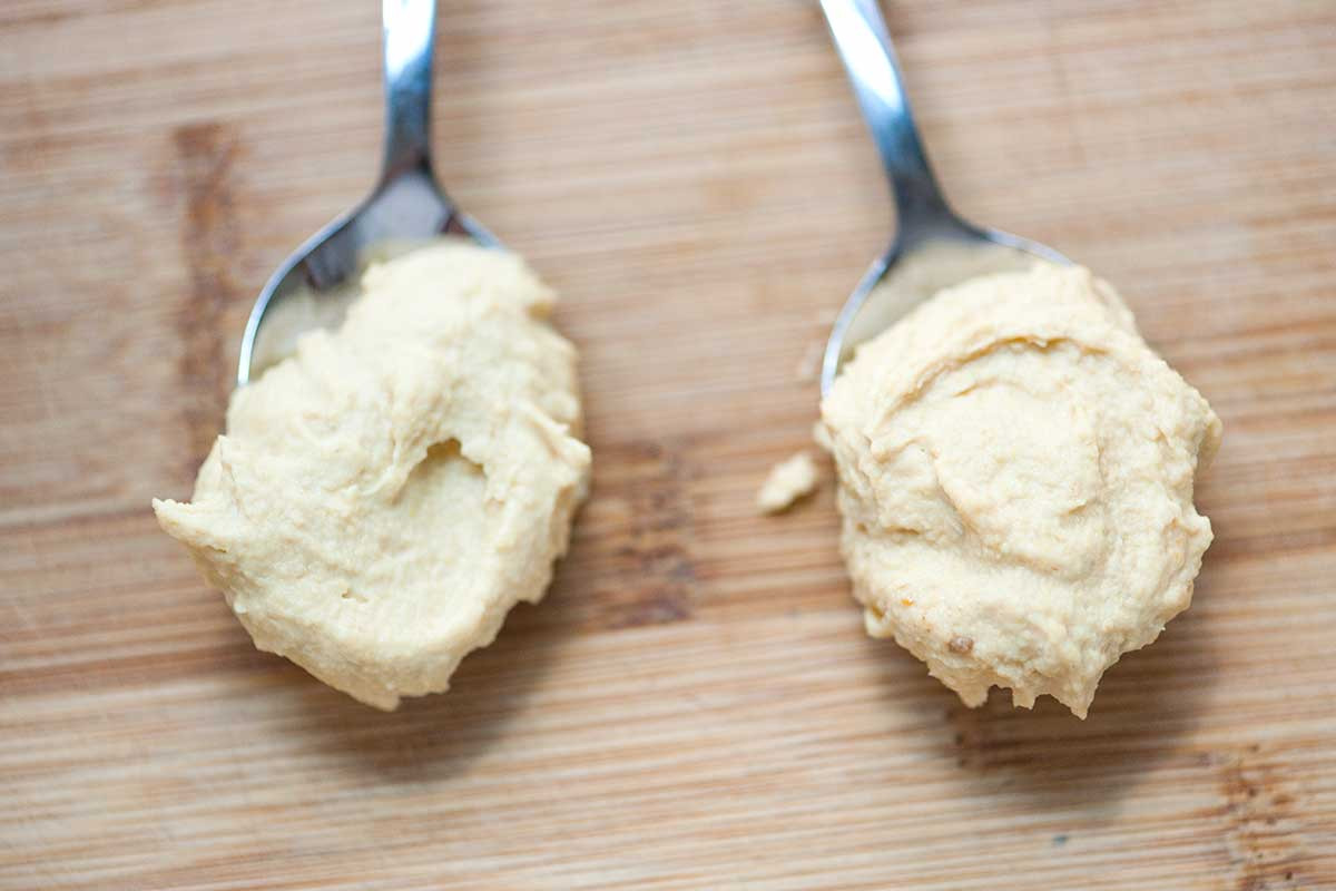 A comparison of hummus made with peeled chickpeas and hummus made with skin-on chickpeas.