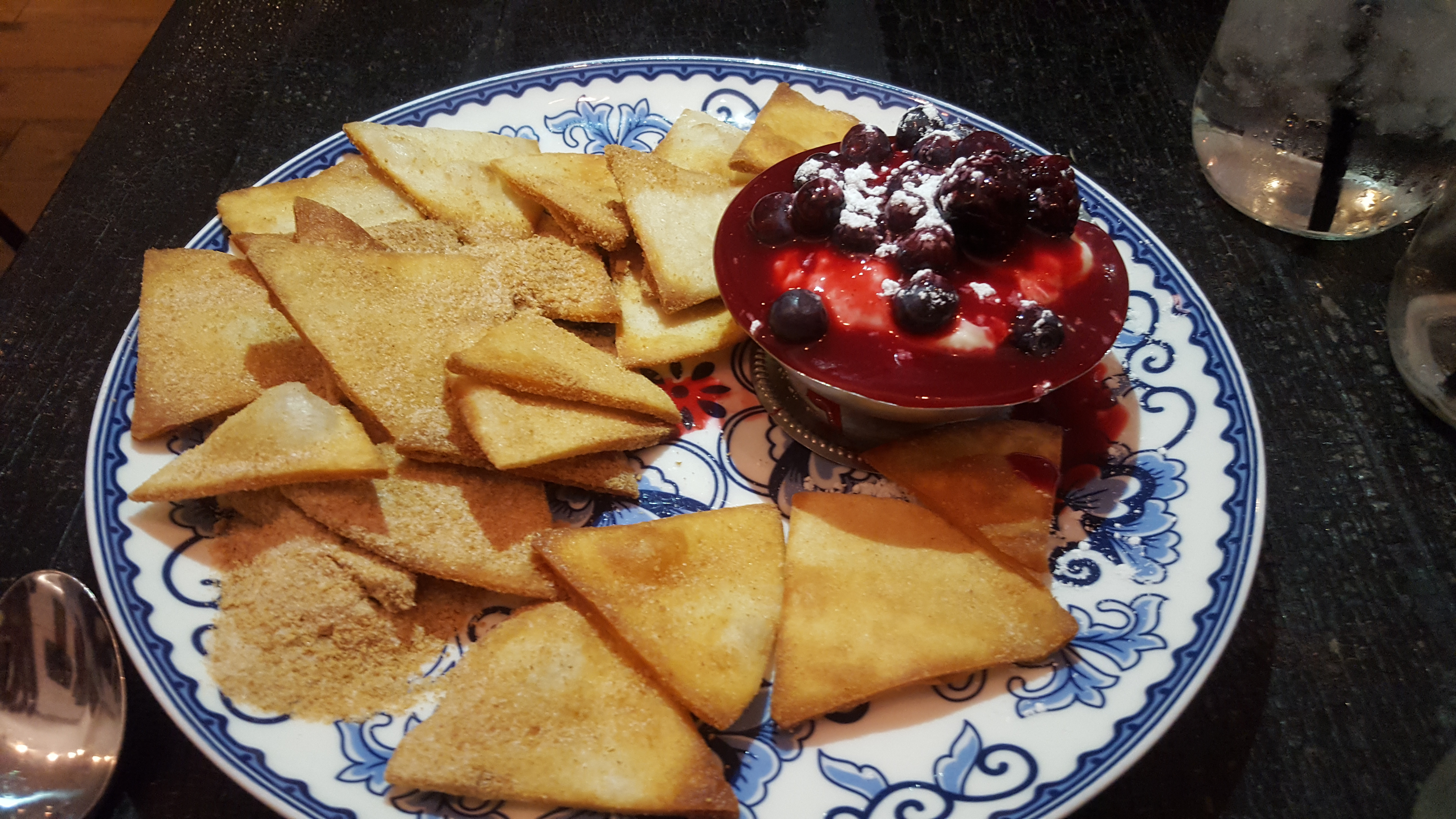 A portion of cheesecake nachos is being held with a fork