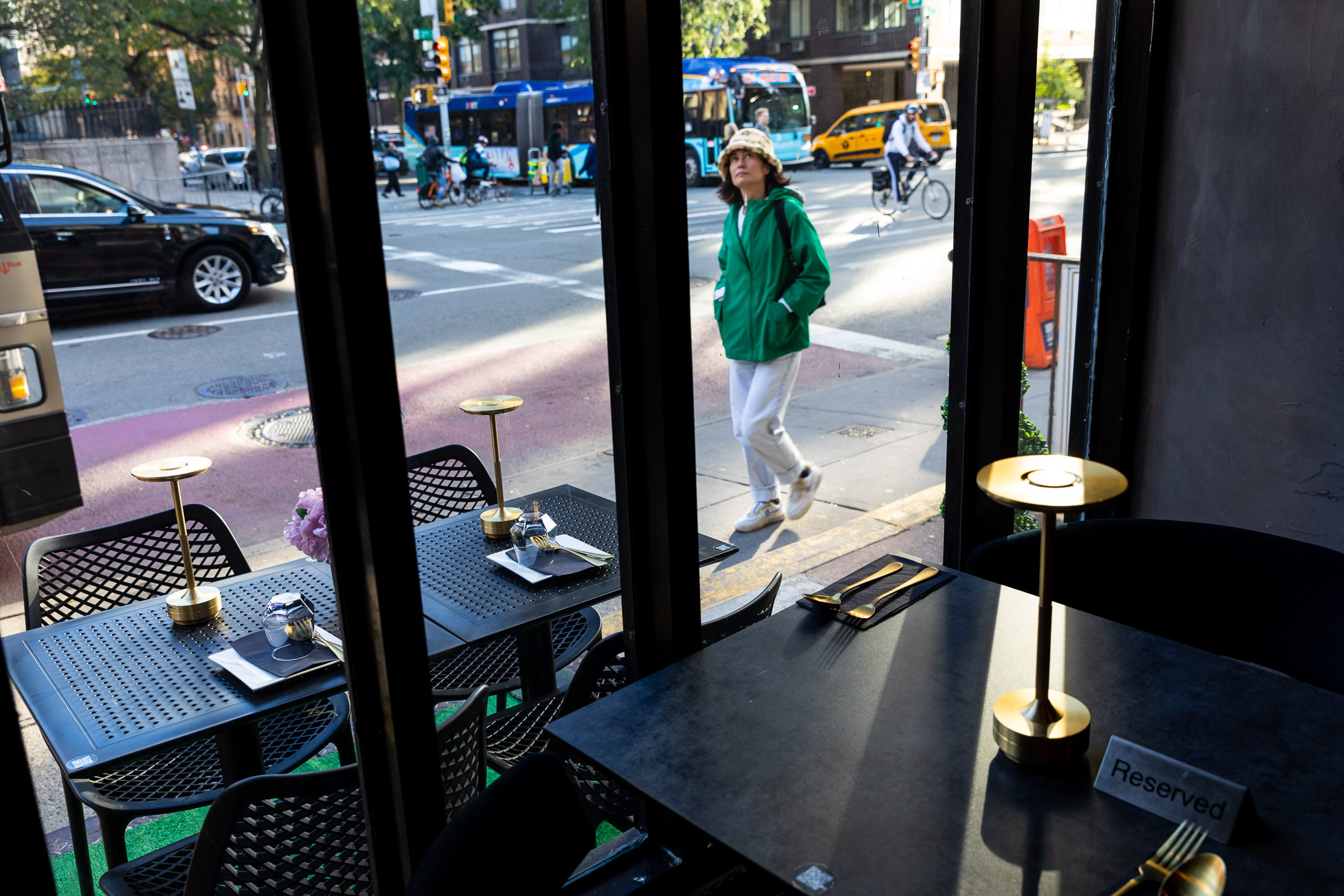 A person passing on the street looks up at Thai Food Near Me’s sign.