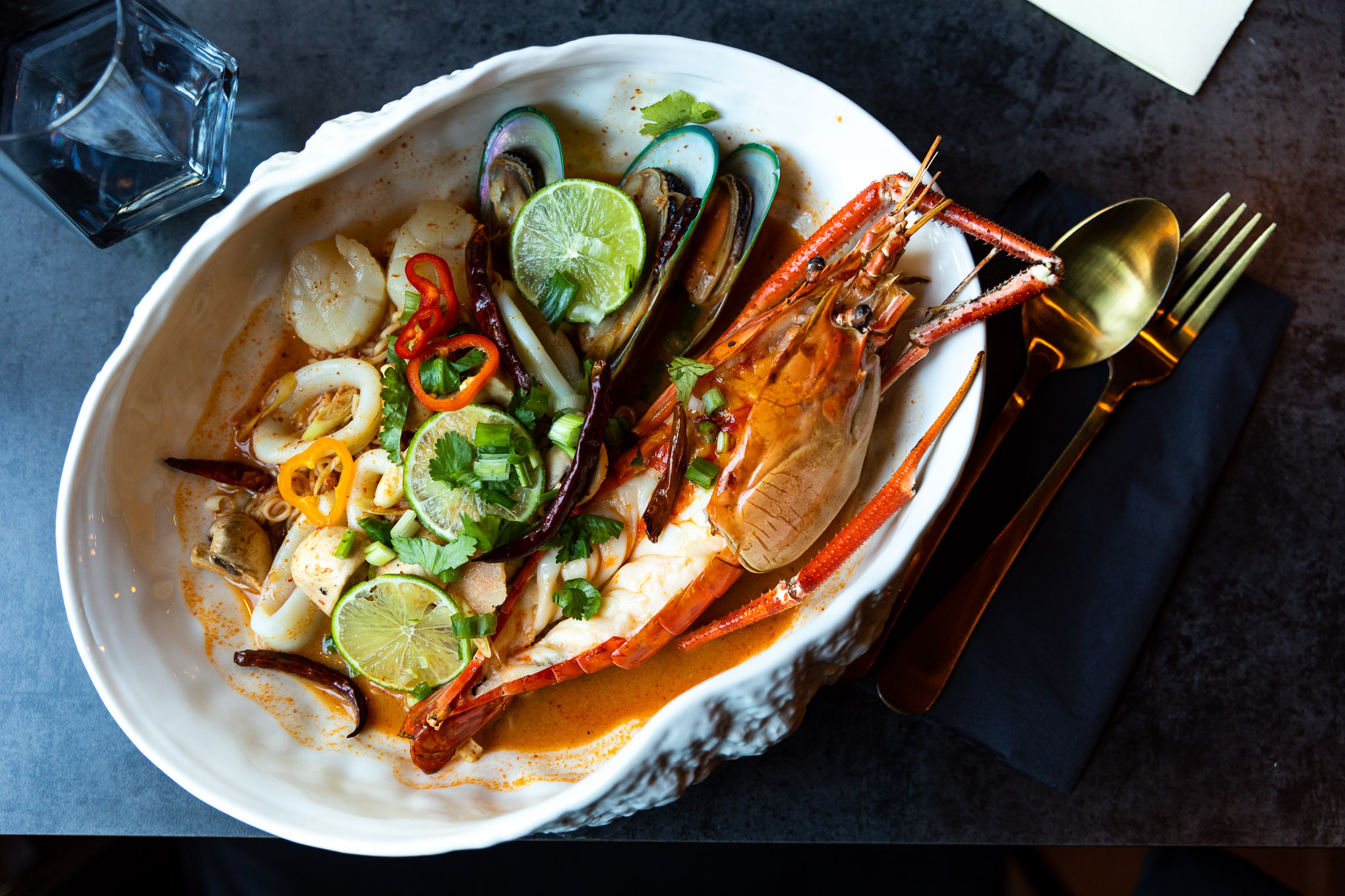 A vibrant and colorful plate of seafood with limes and chili pepper, highlighting the fresh ingredients and bold flavors of Thai Food Near Me.