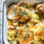 Chicken thighs with colorful roasted vegetables on a sheet pan, showcasing a simple and healthy family meal idea.