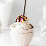 ice cream in a bowl with sprinkles and chocolate sauce drizzled on top