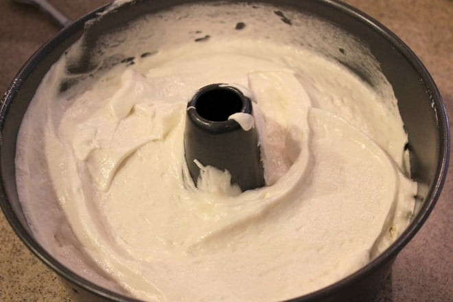 Angel food cake batter being poured into a tube pan