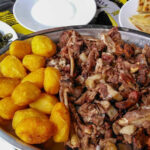 Nyama Choma served on a wooden board with kachumbari and ugali