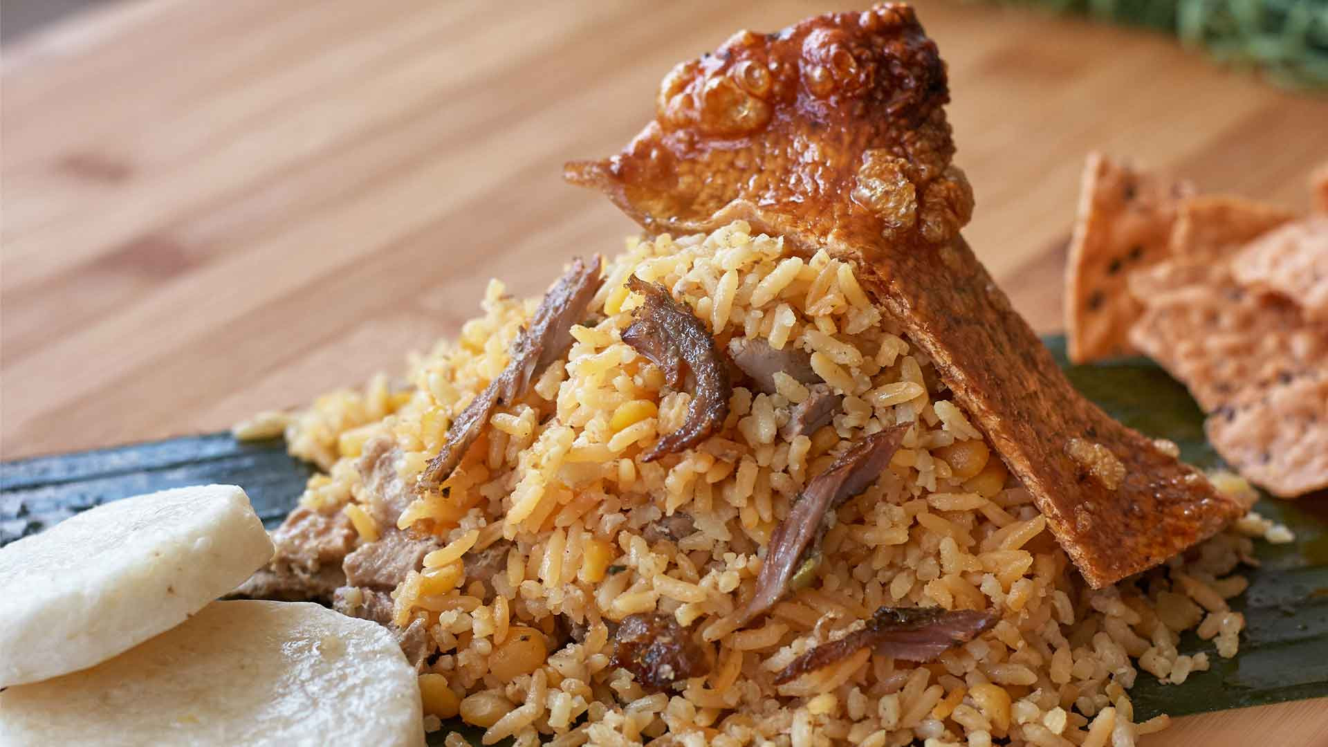 A whole Colombian Lechona, a slow-cooked pork roast filled with rice, onion, vegetables, and spices, showcasing its tender meat, crispy crackling, and flavorful filling, perfect for sharing during special occasions and celebrations.