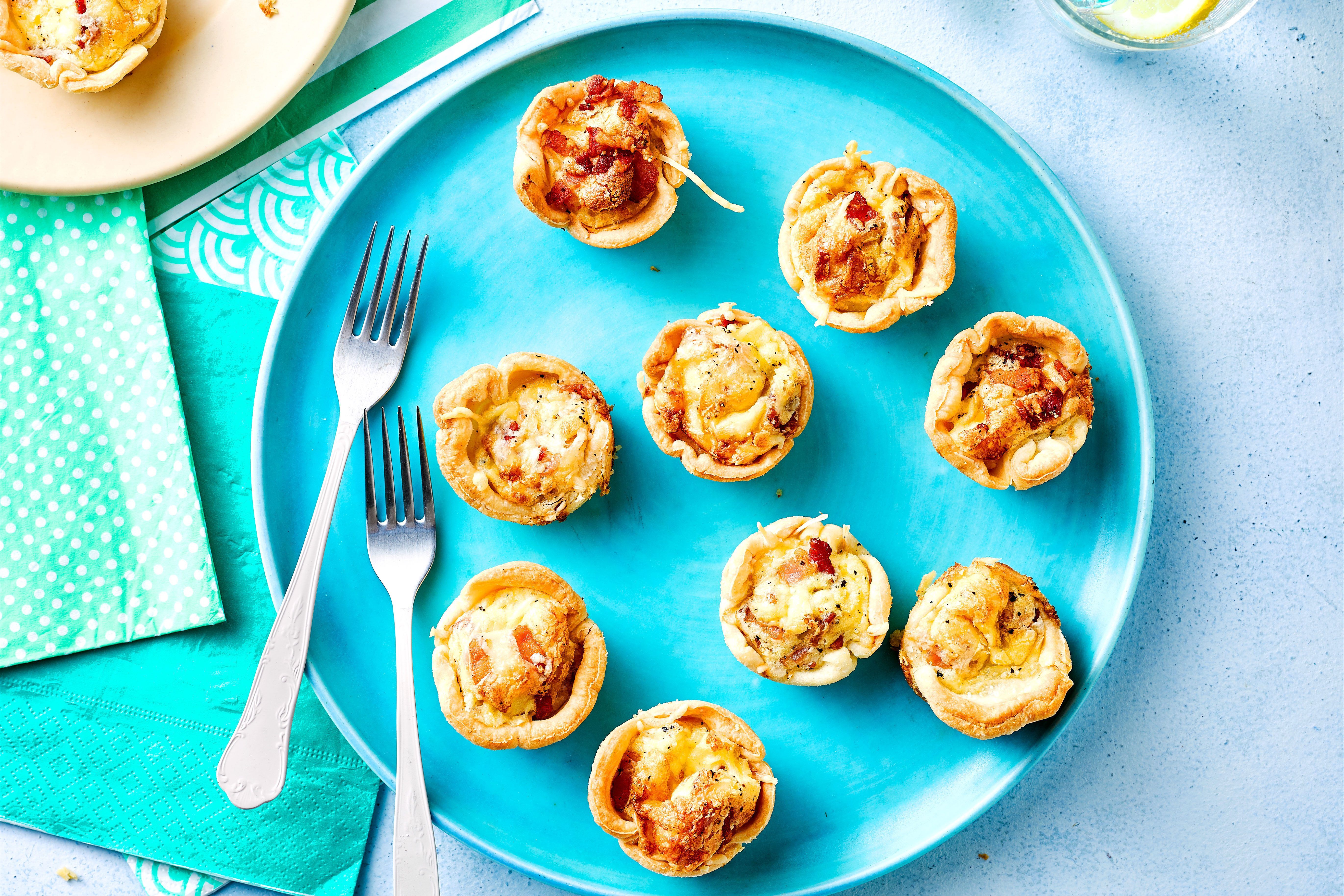 Blue plate with two forks and mini quiches