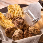 White truffles on a wooden surface, showcasing their earthy appearance and irregular shape