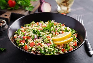 Close-up of fresh quinoa salad with vegetables and herbs