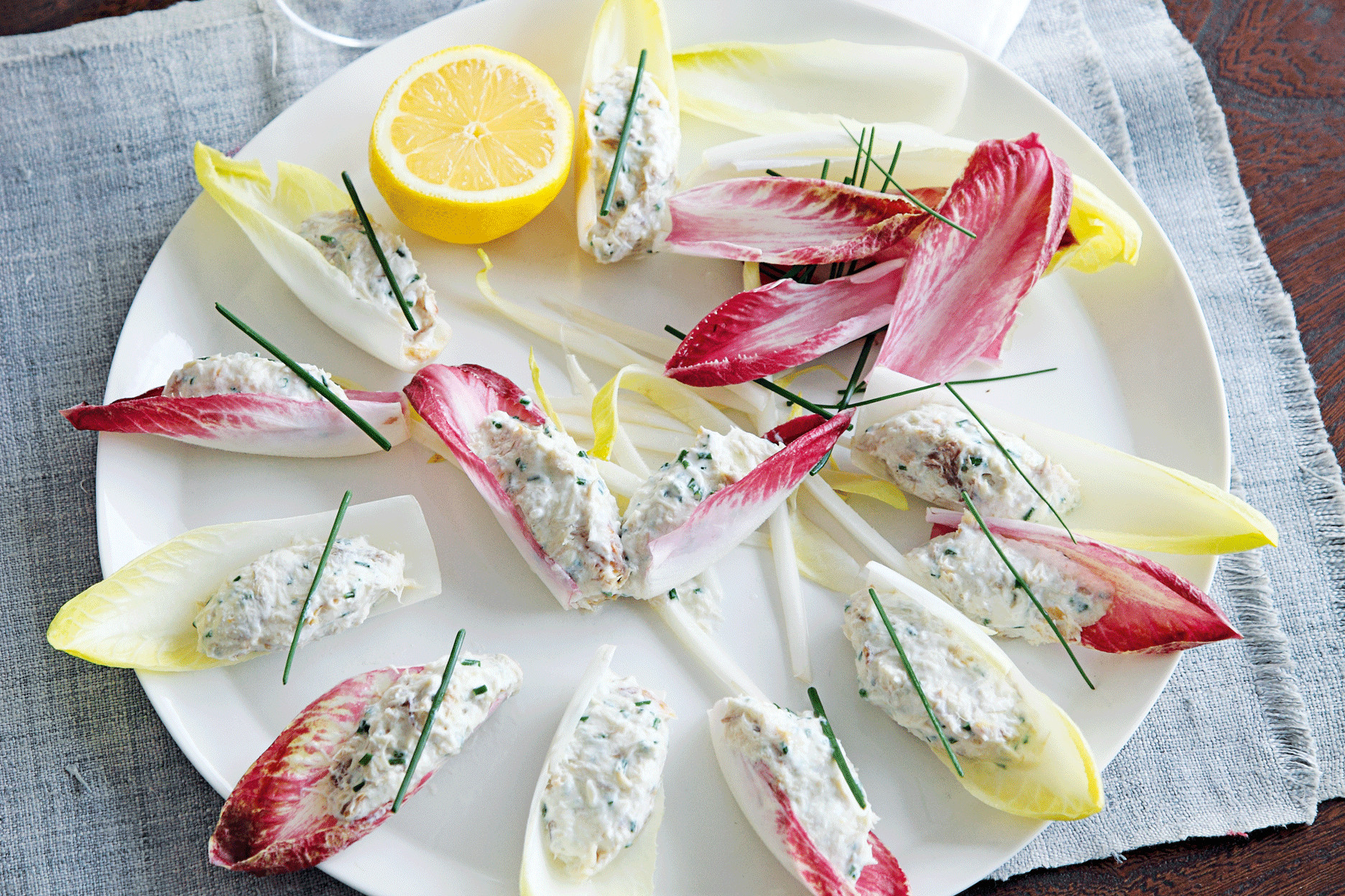 smoked mackerel & horseradish pâté in white and red chicory leaves on a plate with half a lemon